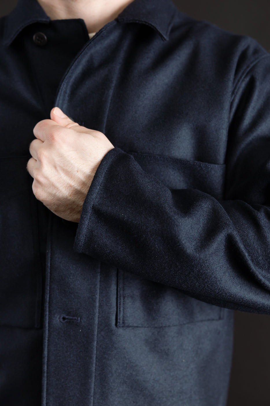 Close-up of front chest and sleeve of navy wool shirt on male model, 5'9