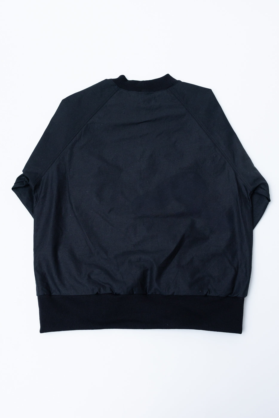 JM8615 - BN Crewneck - 07 Black, showcasing a loose-fitting, long-sleeve pullover with raglan sleeves and a mid-height neck, laid flat to highlight its textured nep yarn fabric and seam pockets.