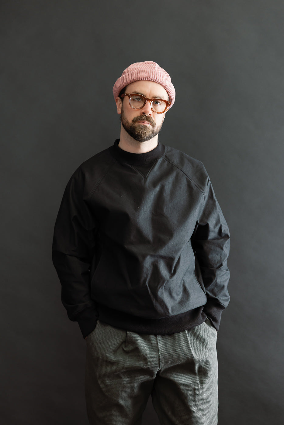 Man wears JM8615 - BN Crewneck, showcasing its loose fit and raglan sleeves. The black sweatshirt features a mid-neck with V-gusset, exemplifying Dant's focus on Japanese workwear craftsmanship.