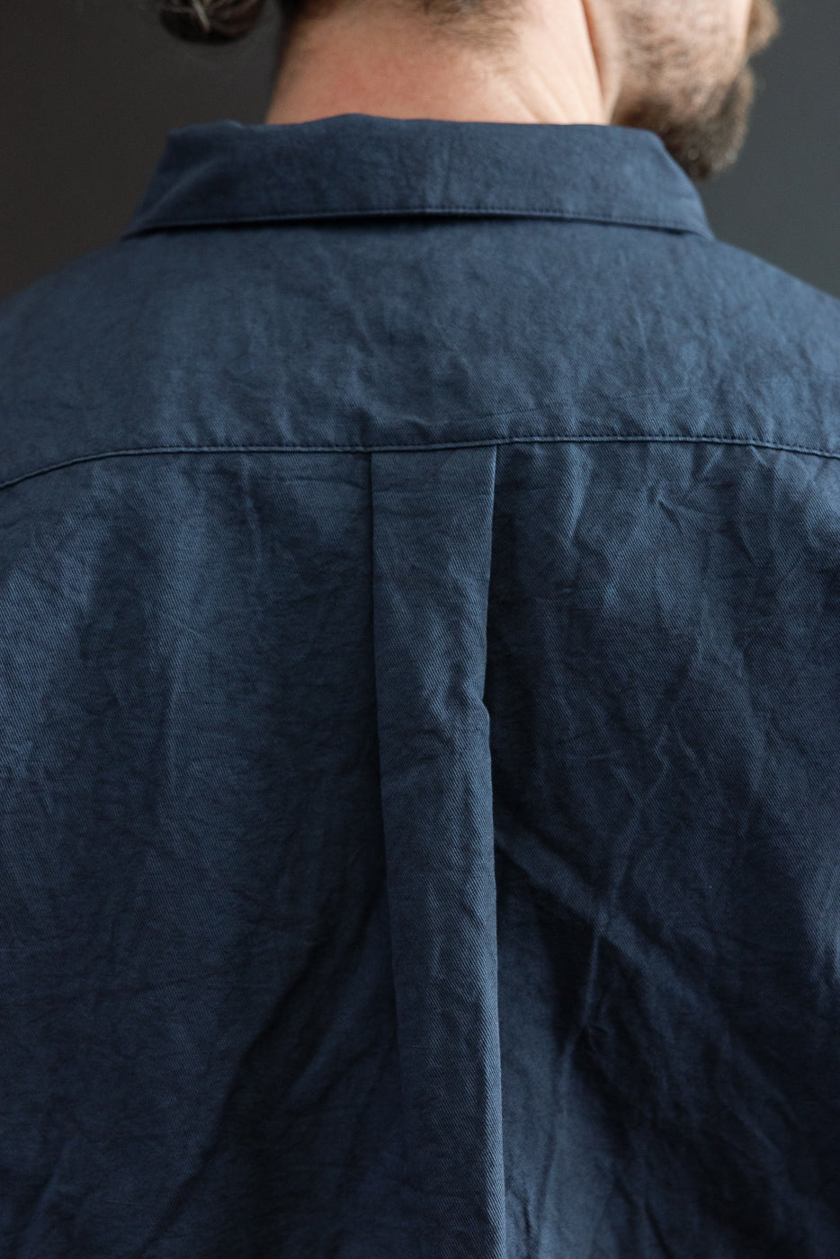 Back view of navy shirt on male model, 5'9