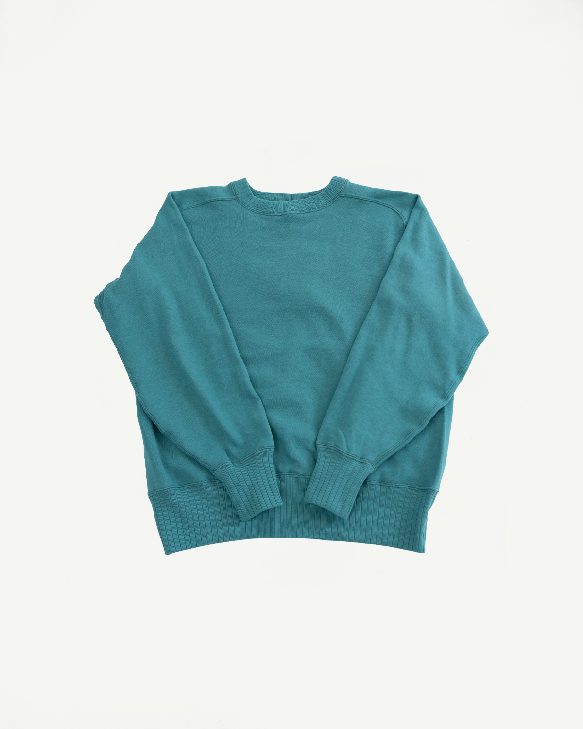 John Gluckow JG-CS24 Albert Sweat in blue-green, laid flat, showcasing its classic crewneck design, freedom sleeve, and seamless sides, reflecting 1940s sportswear authenticity from Dant's heritage-inspired collection.