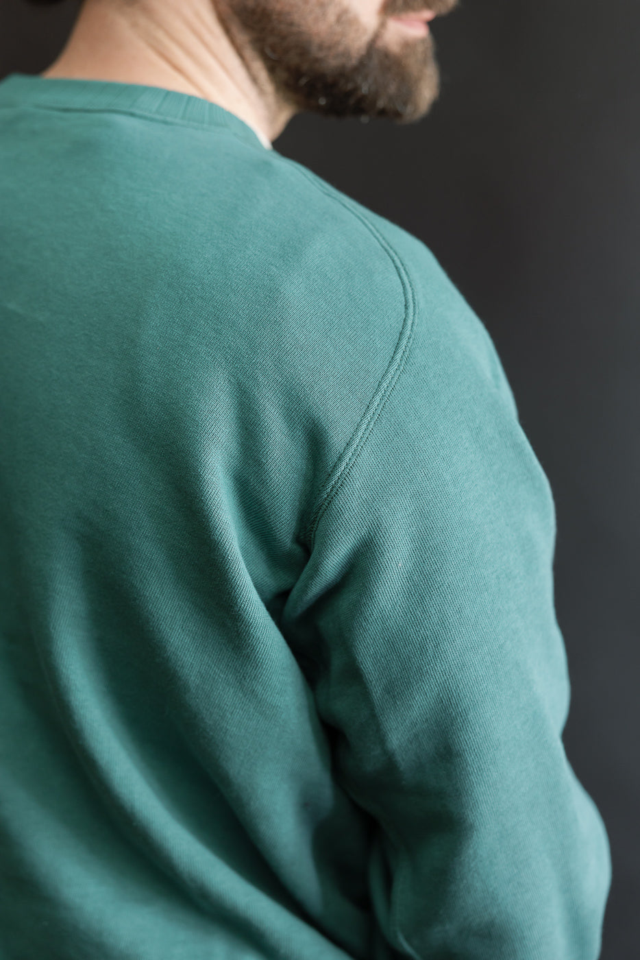 Man wearing the JG-CS24 - The Albert Sweat - Blue Green, showcasing its freedom sleeve design and seamless silhouette, inspired by a vintage 1940s style with a plush, brushed interior.