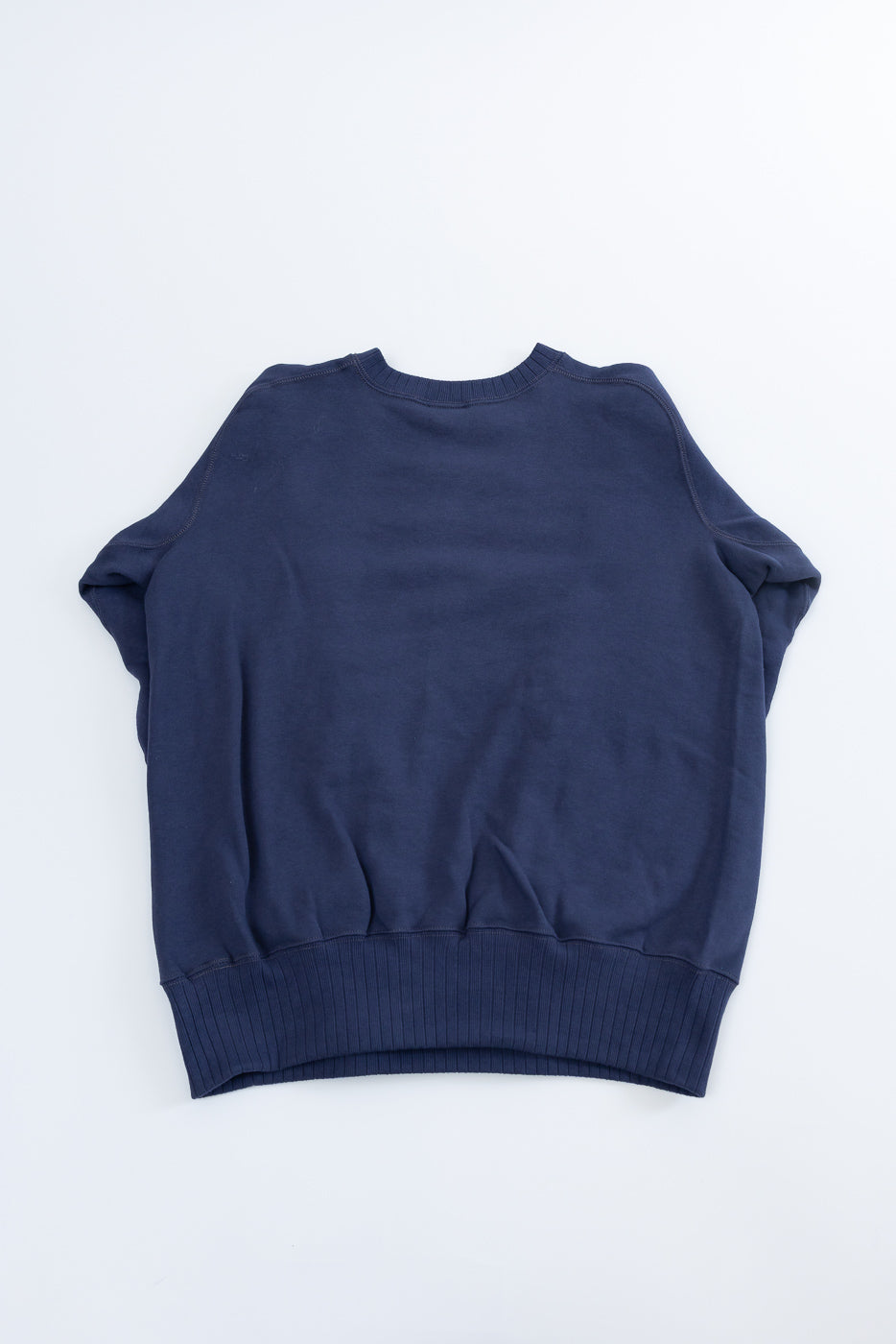 JG-CS24 - The Albert Sweat, a navy-blue crewneck sweatshirt, features ribbed hem and cuffs, echoing 1940s sportswear with its seamless, circular knit for a relaxed, timeless silhouette.