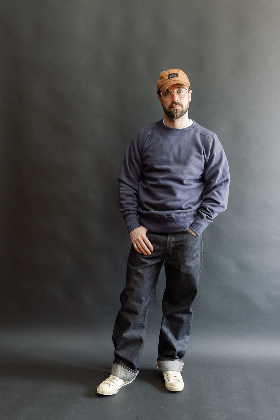 JG-CS24 - The Albert Sweat - Eggplant, worn by a 5'9 Caucasian male, showcasing its relaxed drape and freedom sleeve design, paired with rolled dark denim and canvas sneakers against a neutral backdrop.