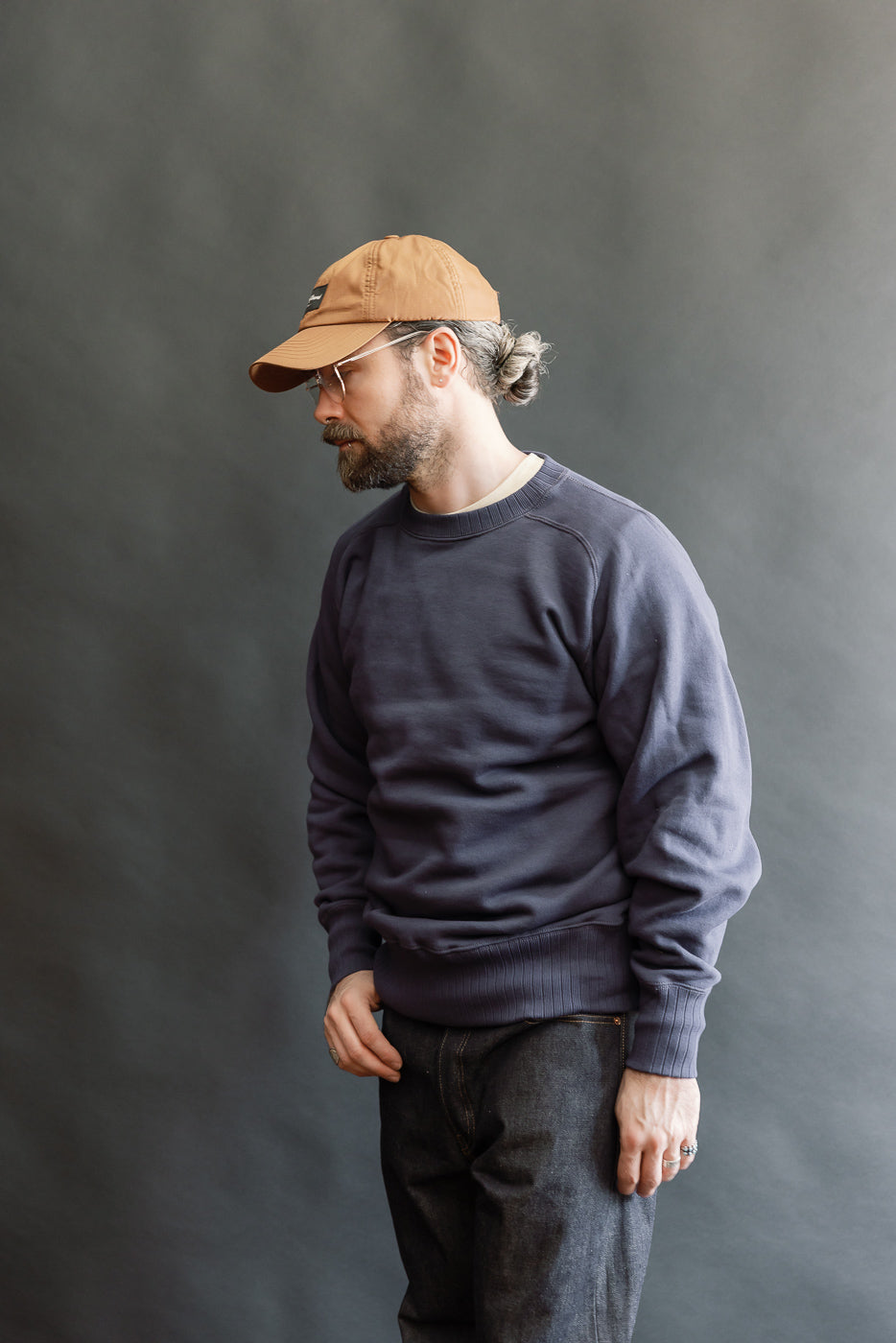 Model wearing the JG-CS24 - The Albert Sweat - Eggplant, showcasing its classic fit and freedom sleeve design. Styled with dark denim, highlighting the sweatshirt's relaxed, seamless silhouette and heritage-inspired craftsmanship.