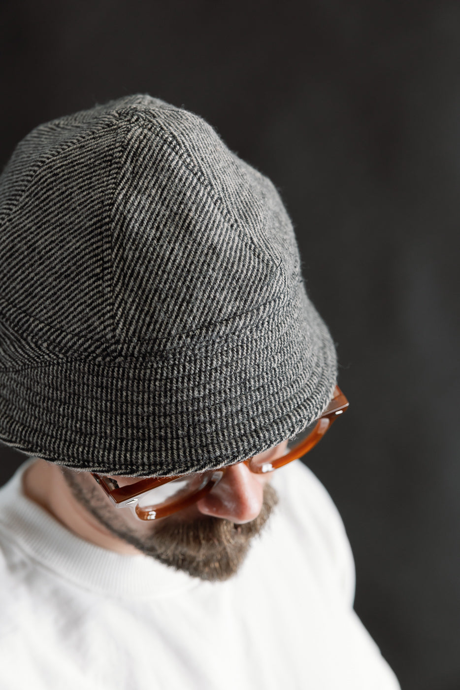 Close-up of John Gluckow Lot JG-31 Tweedy Prison Cap, beige, on male model 5'9 165lbs athletic build, front top view, textured striped fabric detail, Dant contemporary casual accessories.