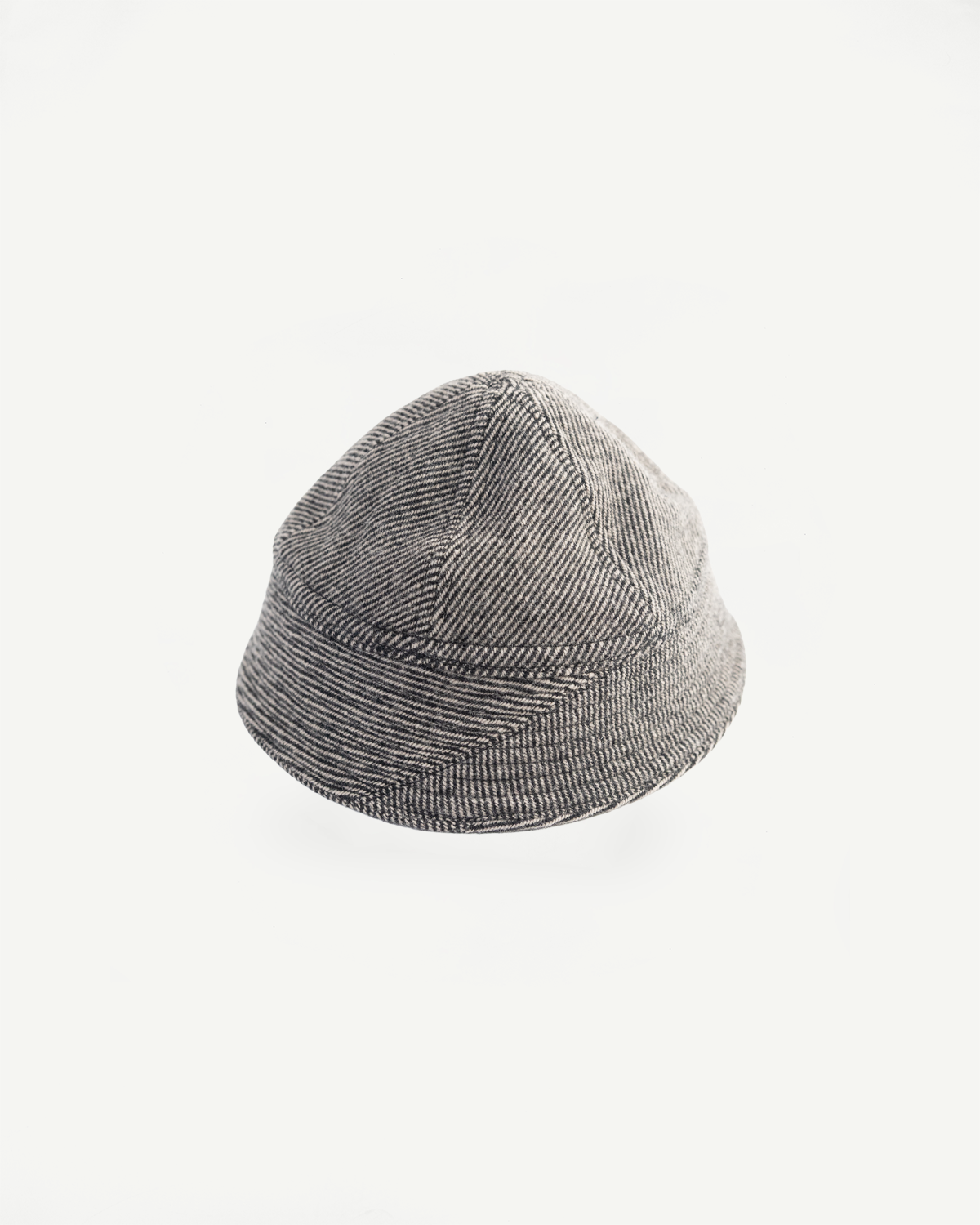 Flat lay front view of John Gluckow tweedy prison cap in beige herringbone texture, Dant shop