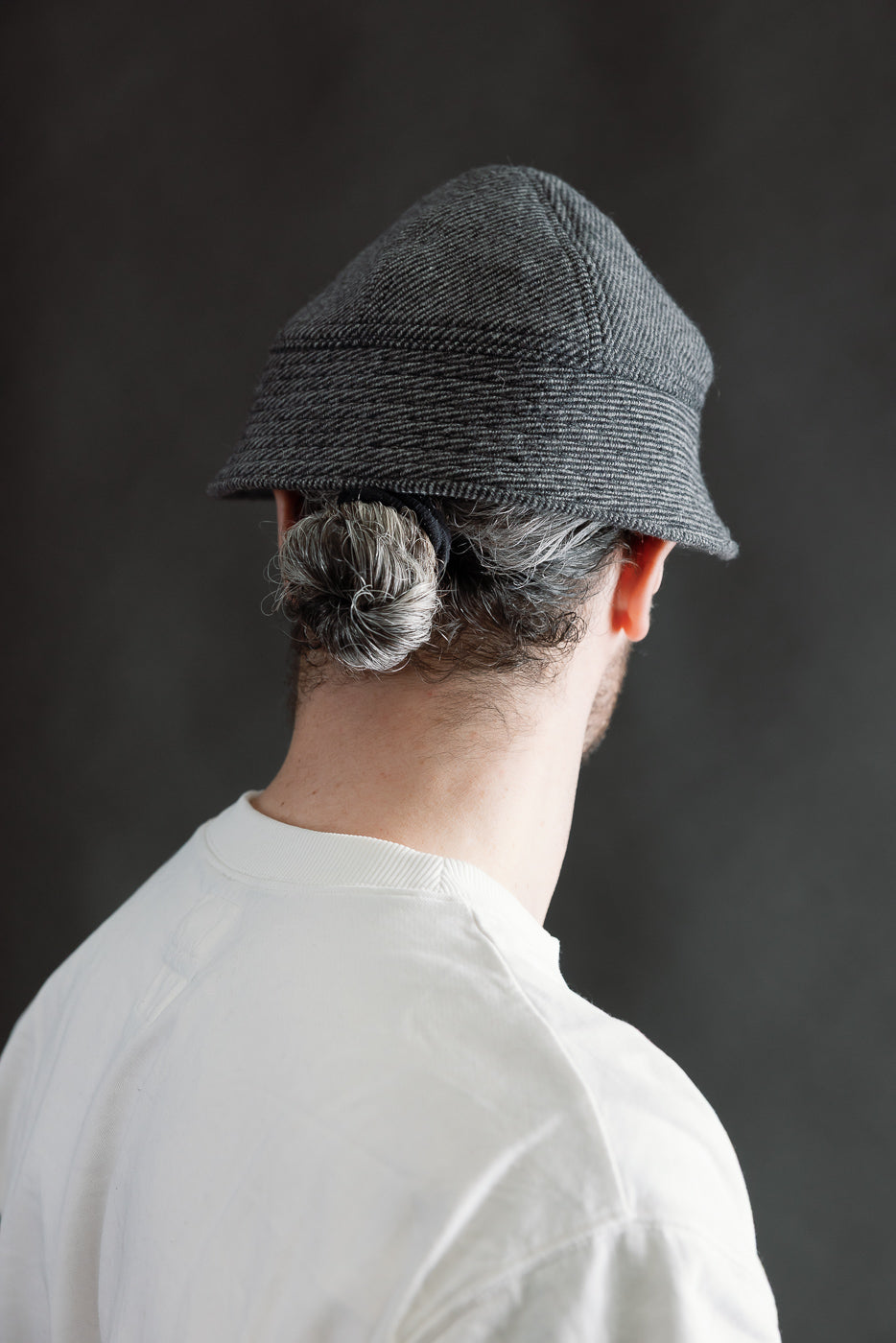 Back view close-up of gray tweedy prison cap on male model, 5'9