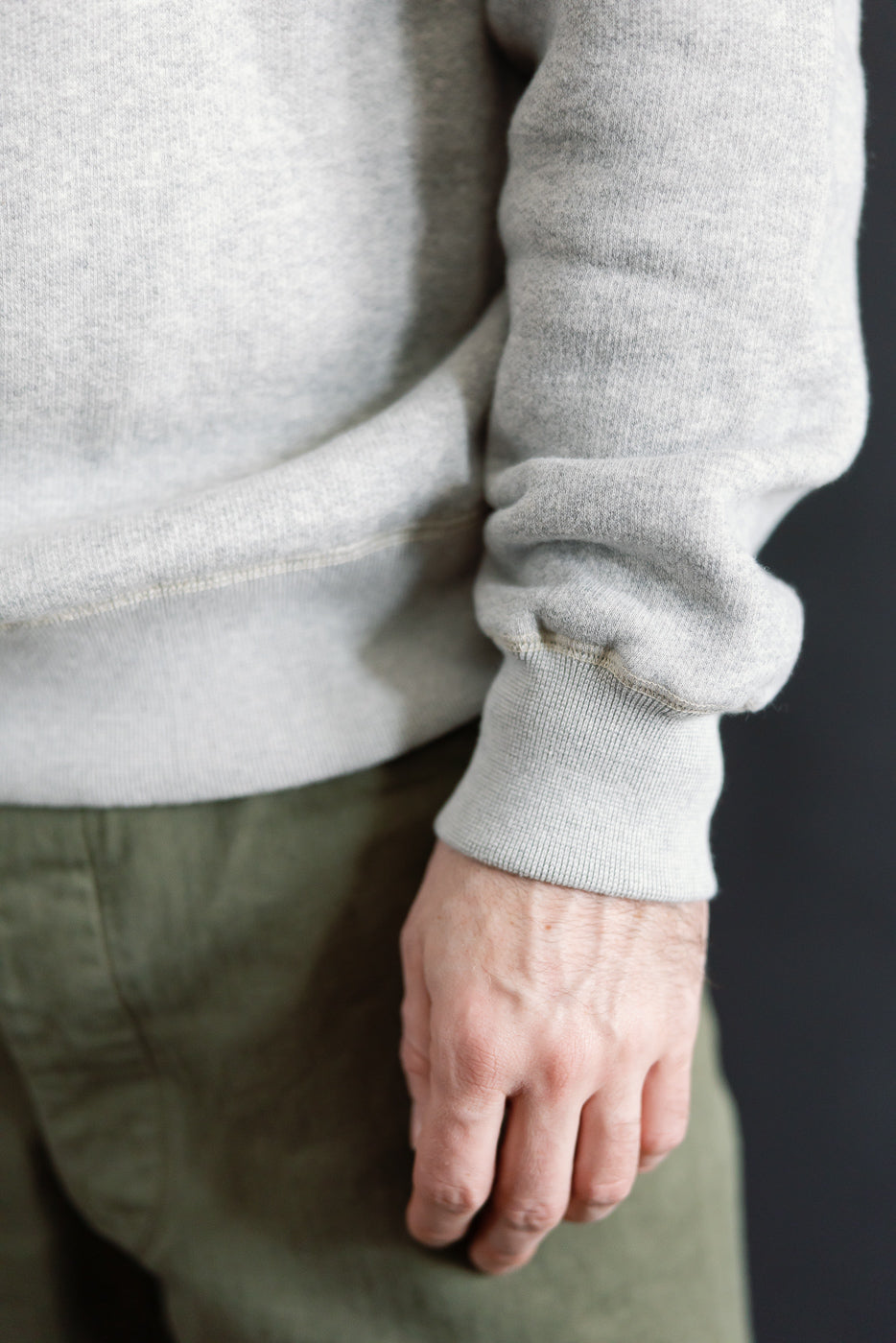 Men's super fluffy knit raglan turtleneck, vintage old melange grey, close-up of right sleeve and ribbed cuff detail on athletic male model, Dant contemporary casual apparel.