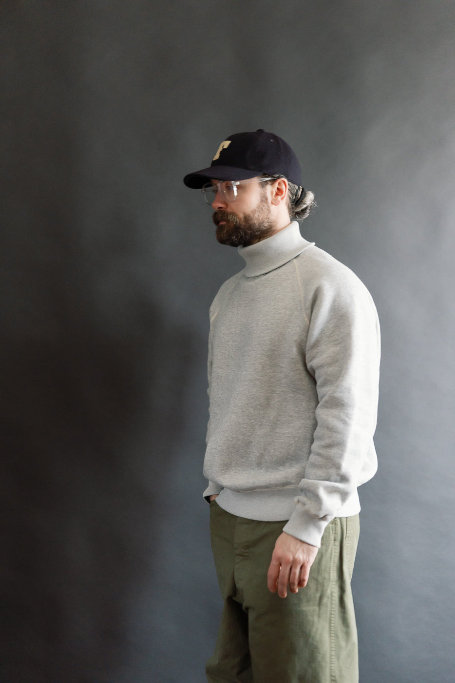 Male model 5'9 165lbs athletic build wearing Loop & Weft grey raglan turtleneck, side view, full body