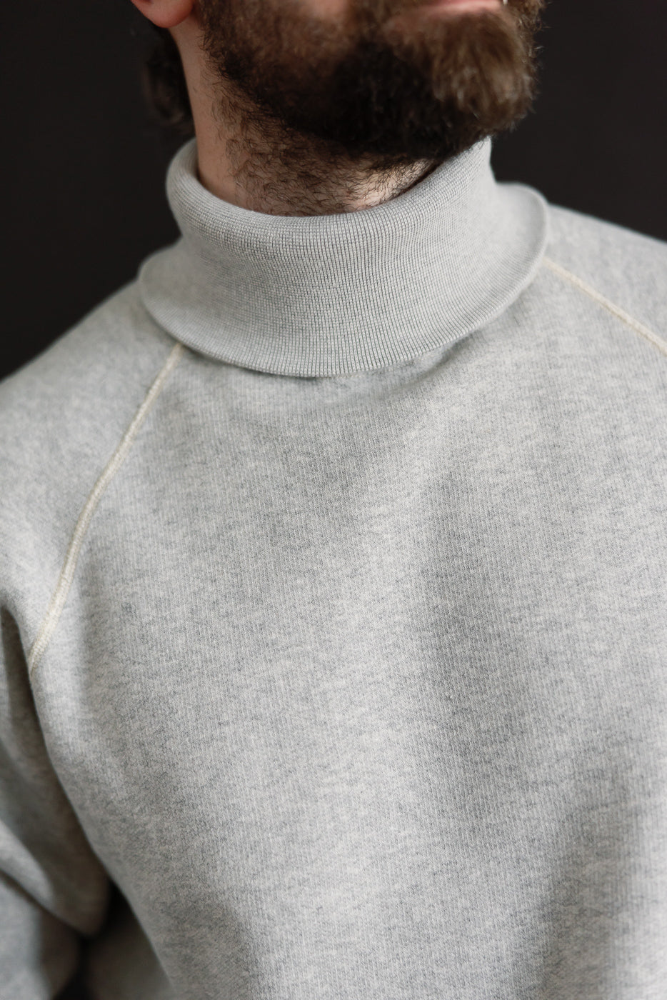 Close-up of men's super fluffy knit raglan turtleneck, front collar detail, vintage grey, model is male, 5'9