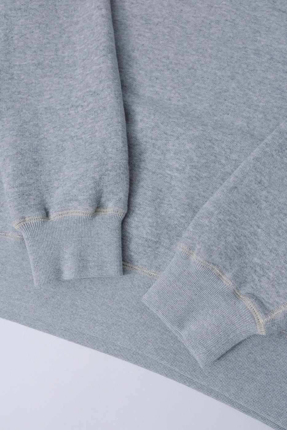 Close-up of Loop & Weft vintage old melange grey knit turtleneck, showing ribbed sleeve cuffs and hem, flat lay front detail.