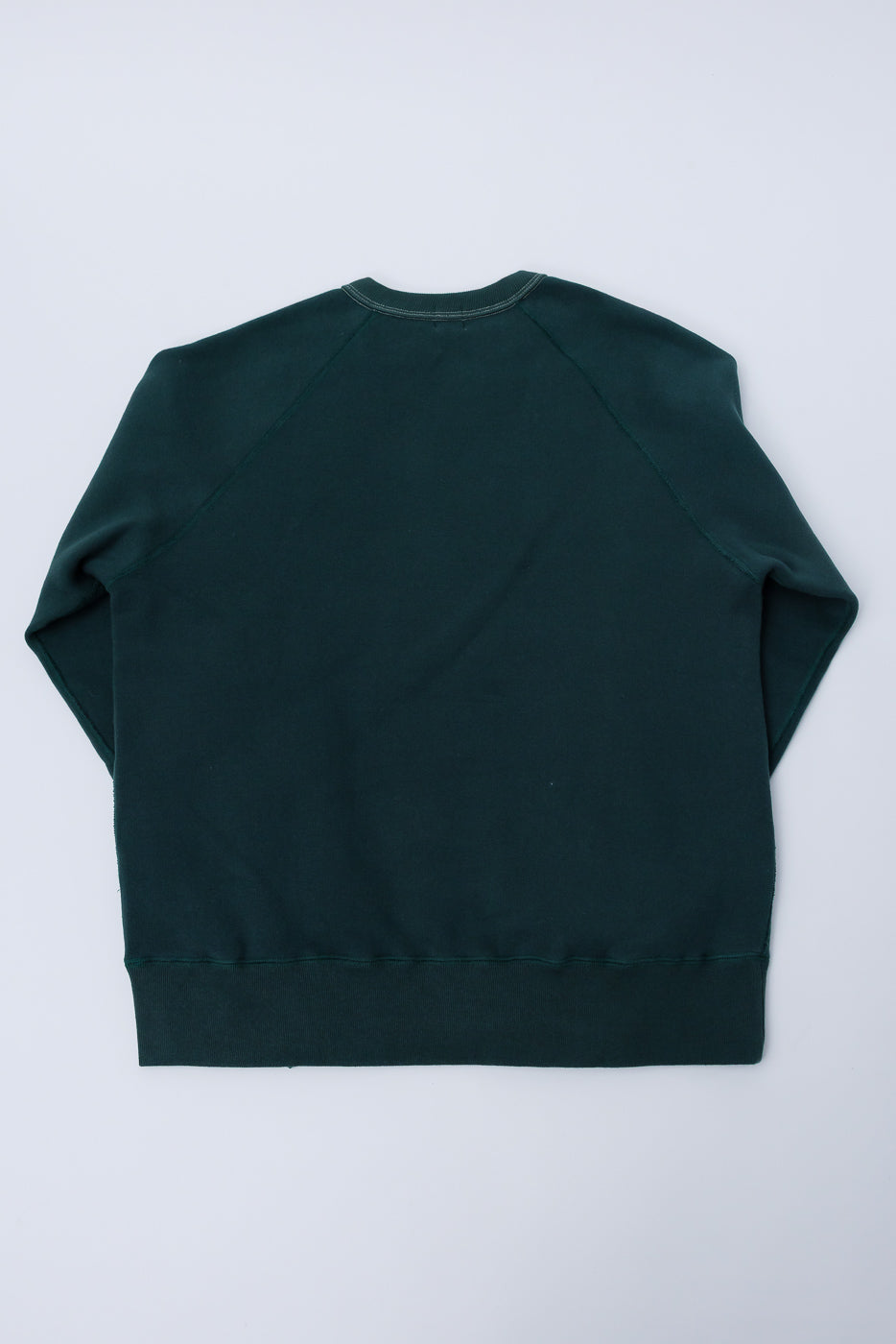 Flat lay of Loop & Weft forest green crew neck sweatshirt, back view, showing raglan sleeves and ribbed hem.