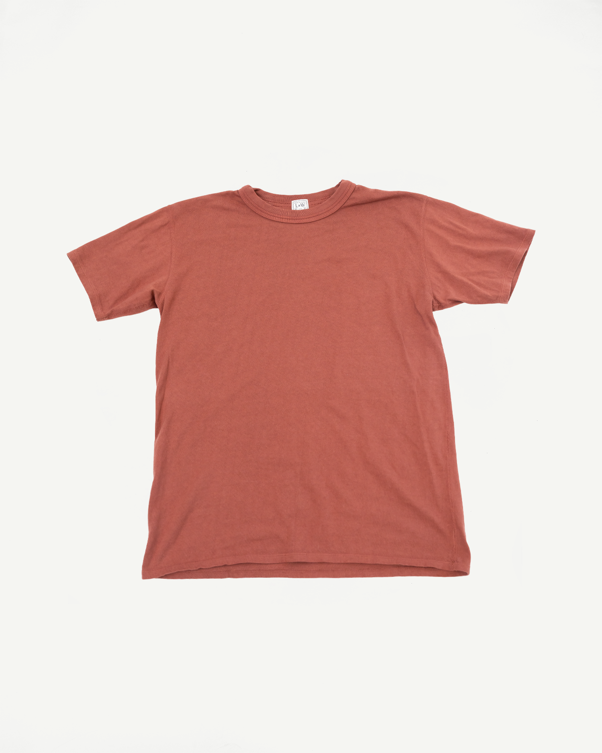 Rust-colored ribbed crewneck t-shirt, front flat lay, showing tag at collar and straight hem