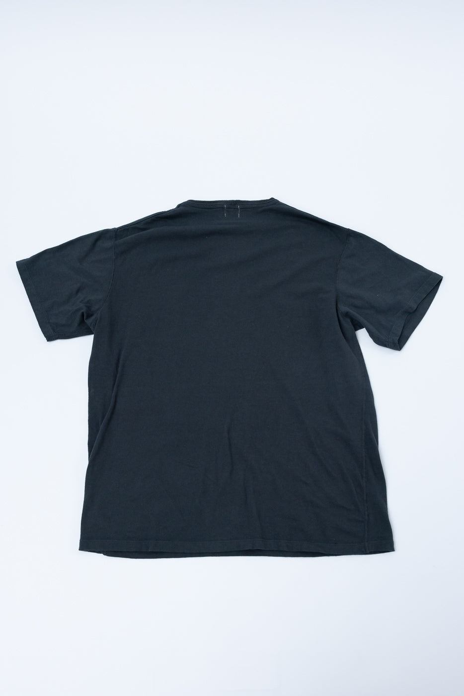 Black crew neck t-shirt back view, flat lay, showing hem and sleeve details