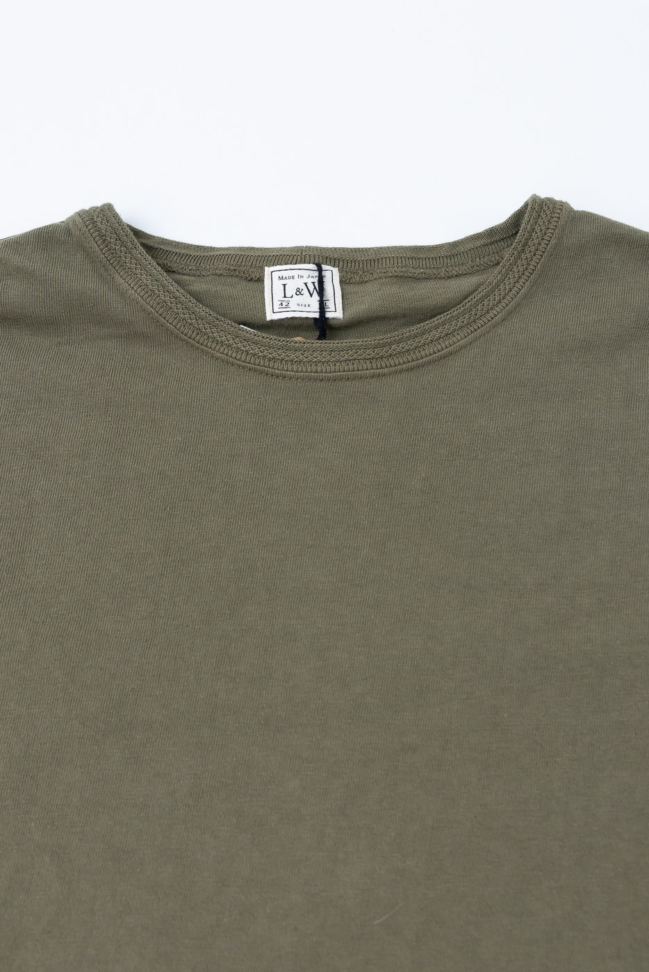 Olive green tee close-up, front view showing ribbed crew neck and L&W brand tag, Made in Japan.