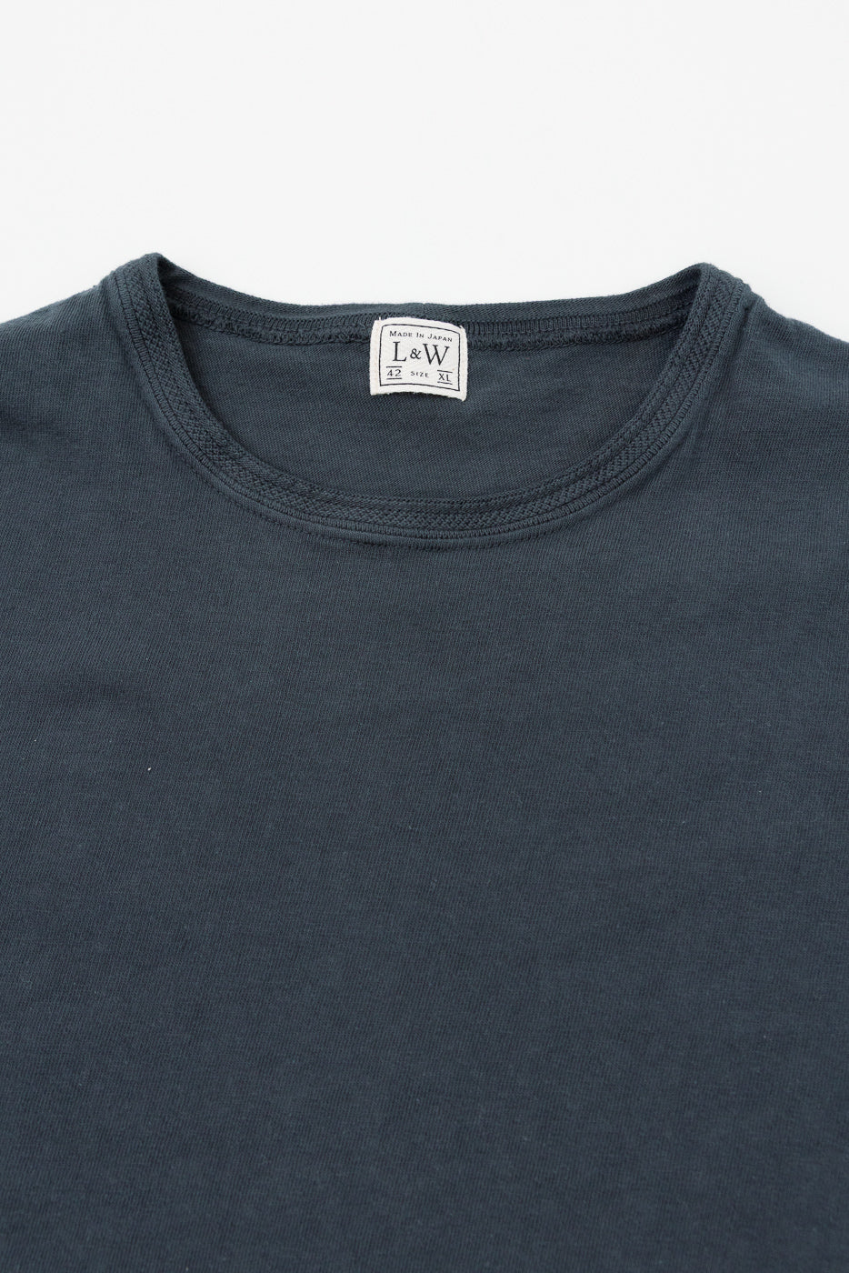 Close-up of dark gray t-shirt collar with L&W tag, front view, Made in Japan, size XL