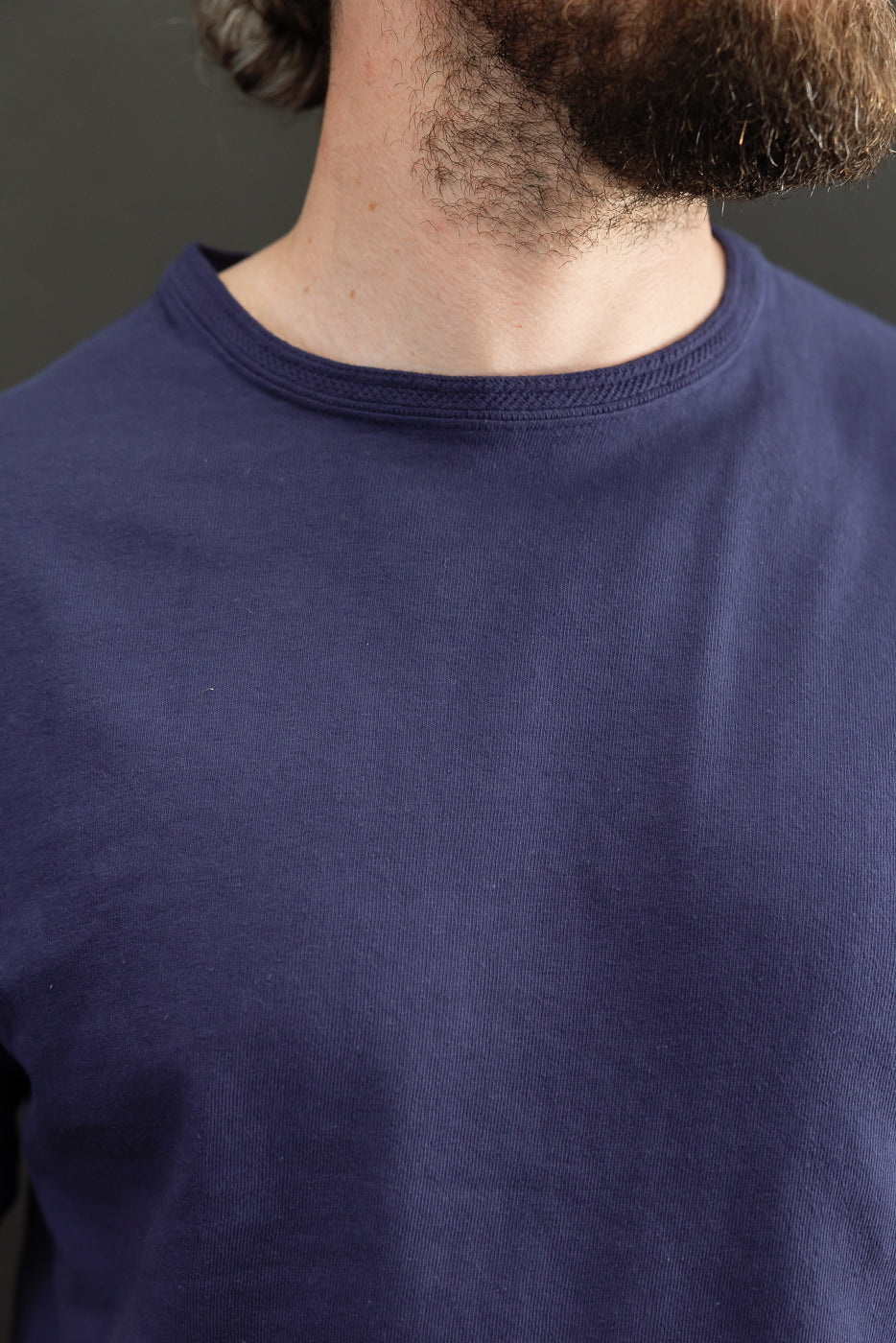 Close-up front view of navy crew neck tee on male model, 5'9