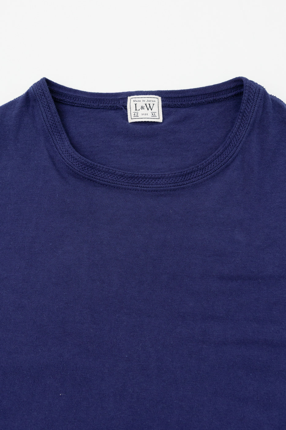 Close-up front view of navy t-shirt showing ribbed crew neck and L&W tag, Made in Japan, size XL