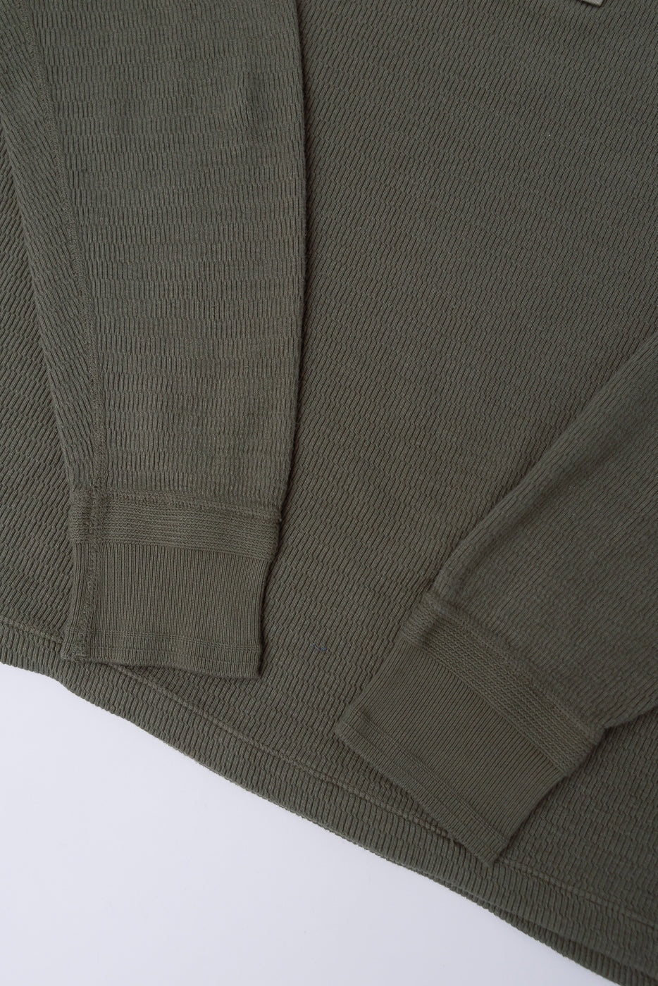 Close-up of front hem and sleeve cuffs on Loop & Weft Supima honeycomb knit thermal in army olive.