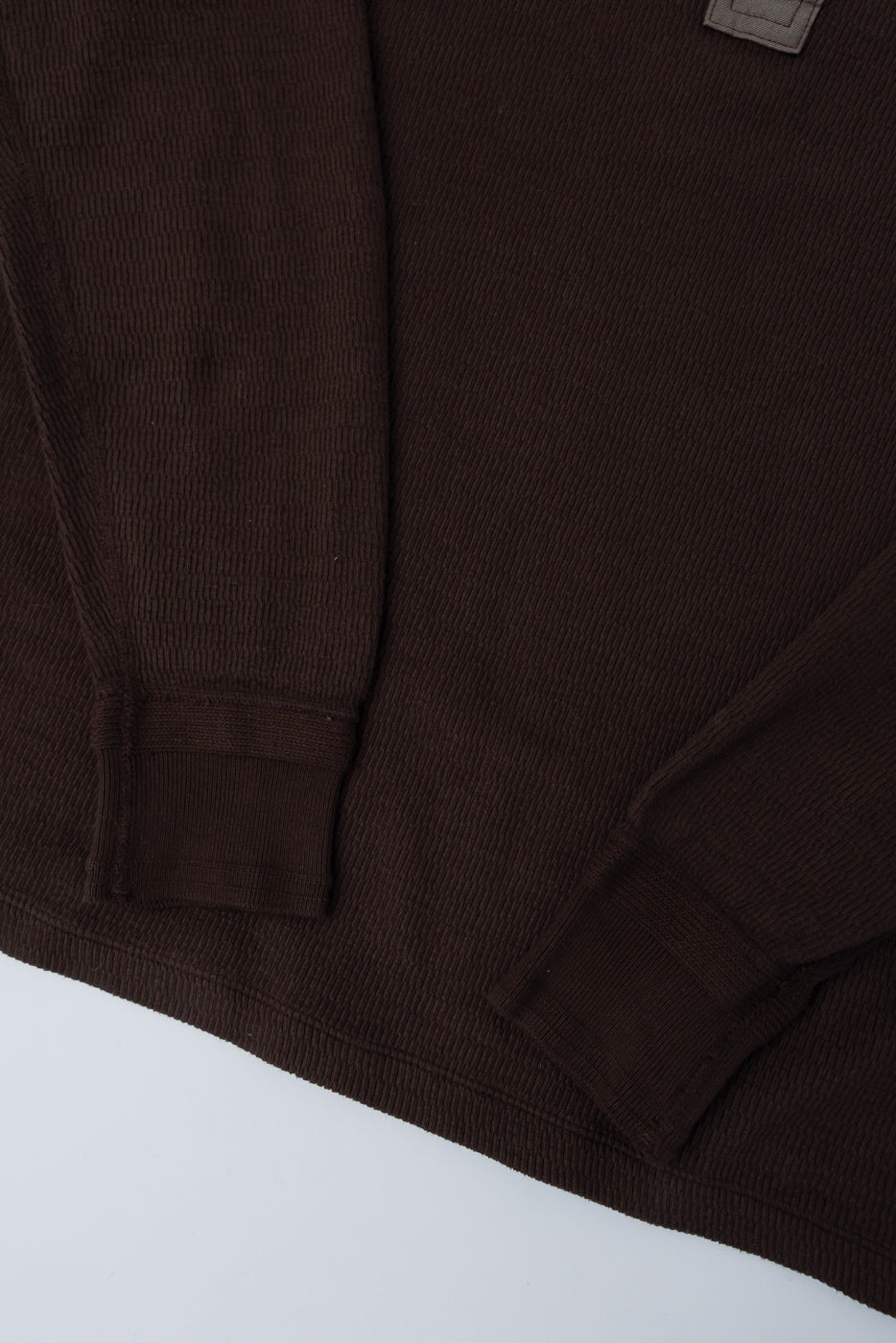 Close-up of front hem and sleeves, brown honeycomb knit thermal, showing fabric texture and cuffs.