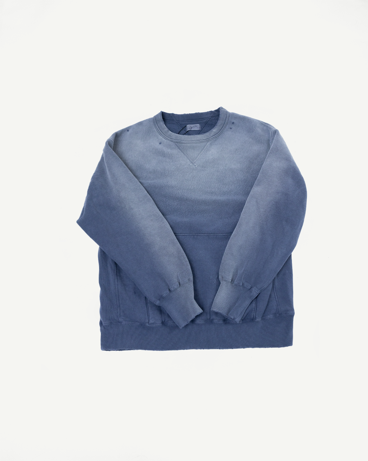 Front view flat lay of a faded blue crewneck sweatshirt with ribbed cuffs and hem.