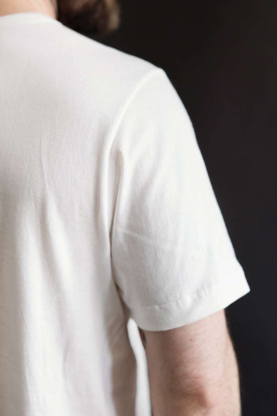 Close-up of male model's back and sleeve in white loopwheeled T-shirt, classic fit, athletic build