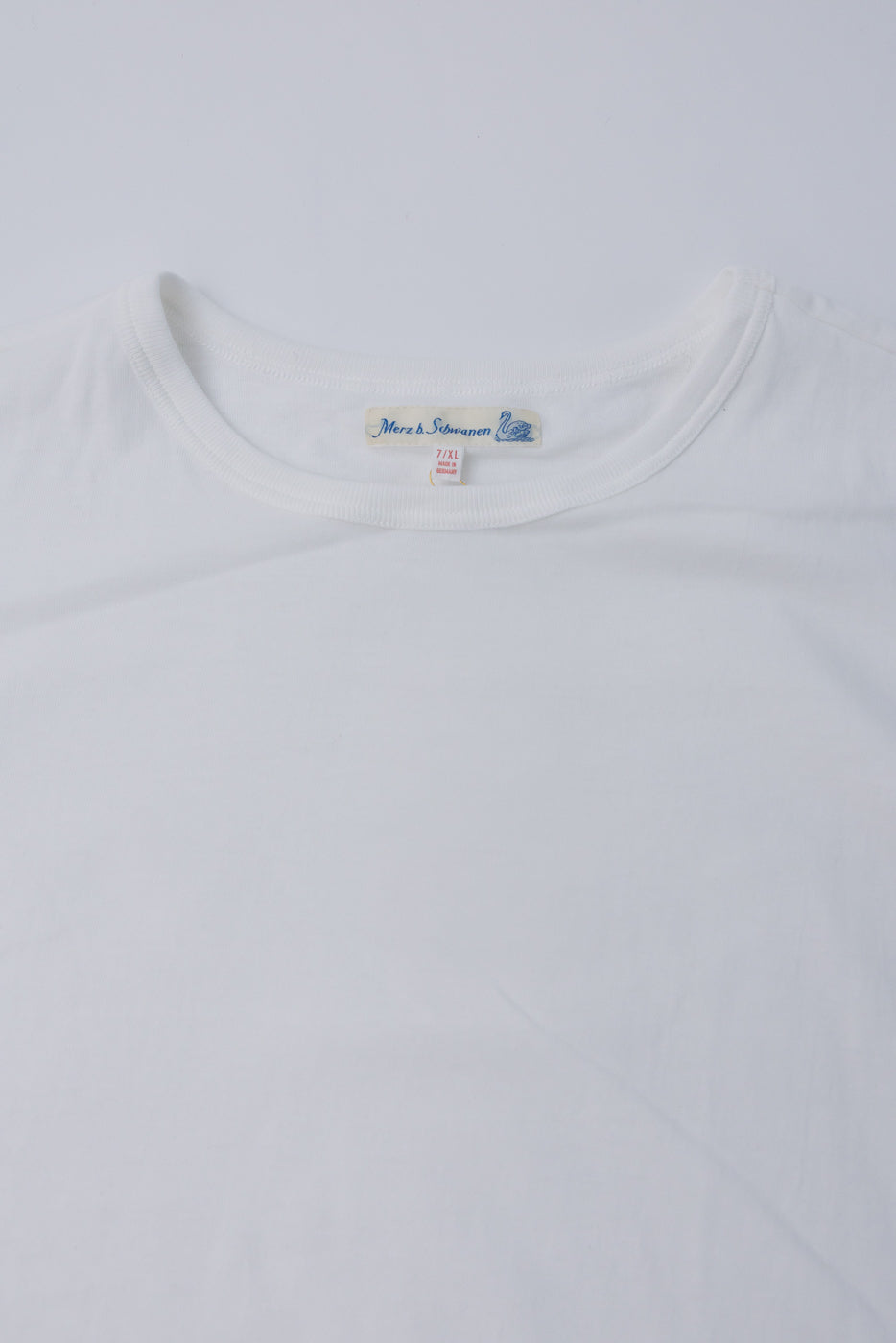 Close-up of Merz b. Schwanen white loopwheeled T-shirt, front collar and tag detail