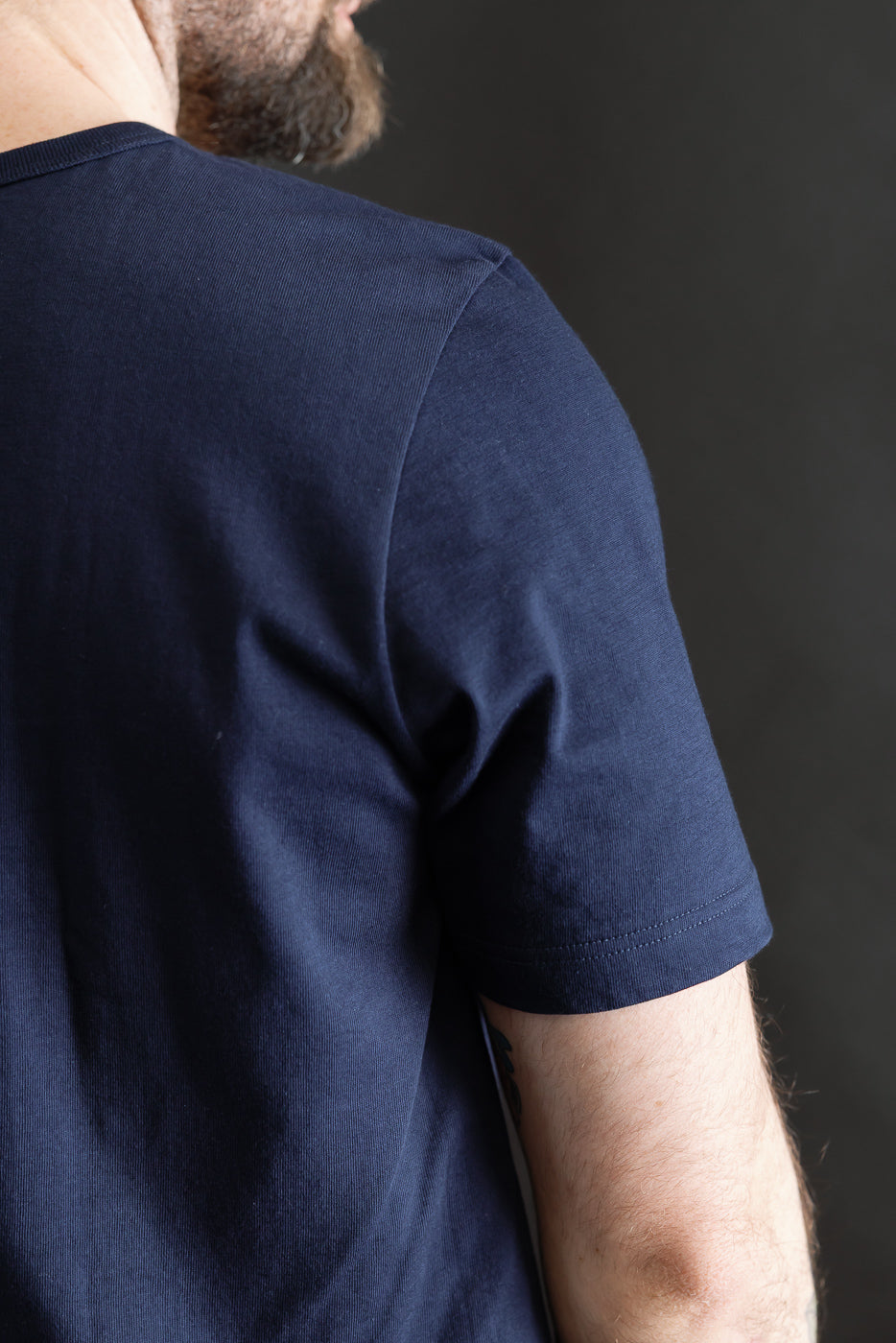 Close-up of ink blue loopwheeled t-shirt back right shoulder on 5'9