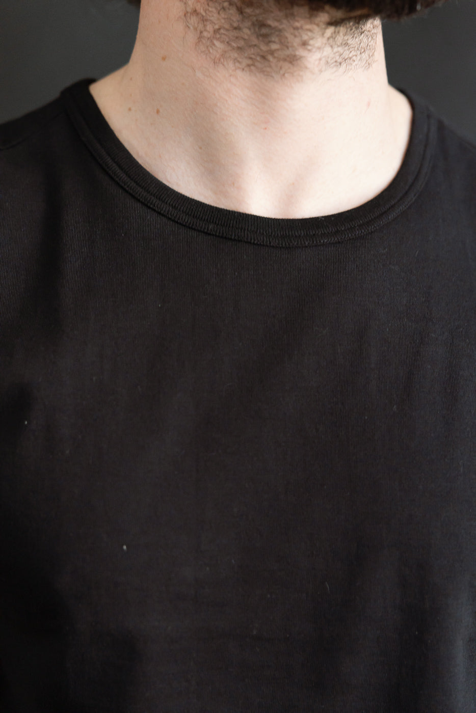 Close-up front of Merz b. Schwanen deep black loopwheeled T-shirt, male model, crewneck detail