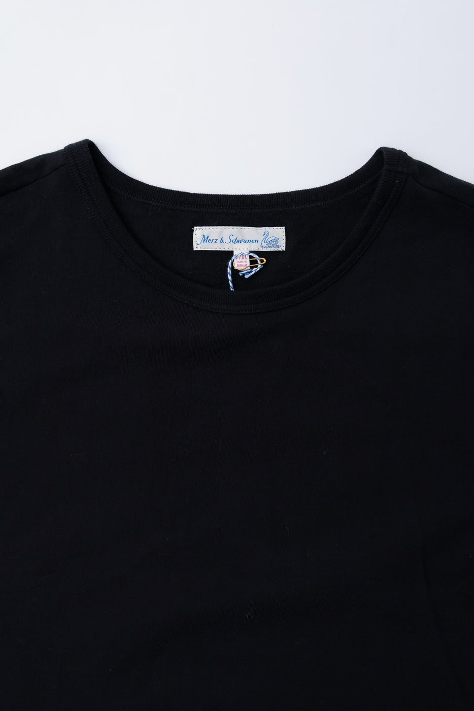 Close-up front view of Merz b. Schwanen deep black classic fit loopwheeled T-shirt collar and tag
