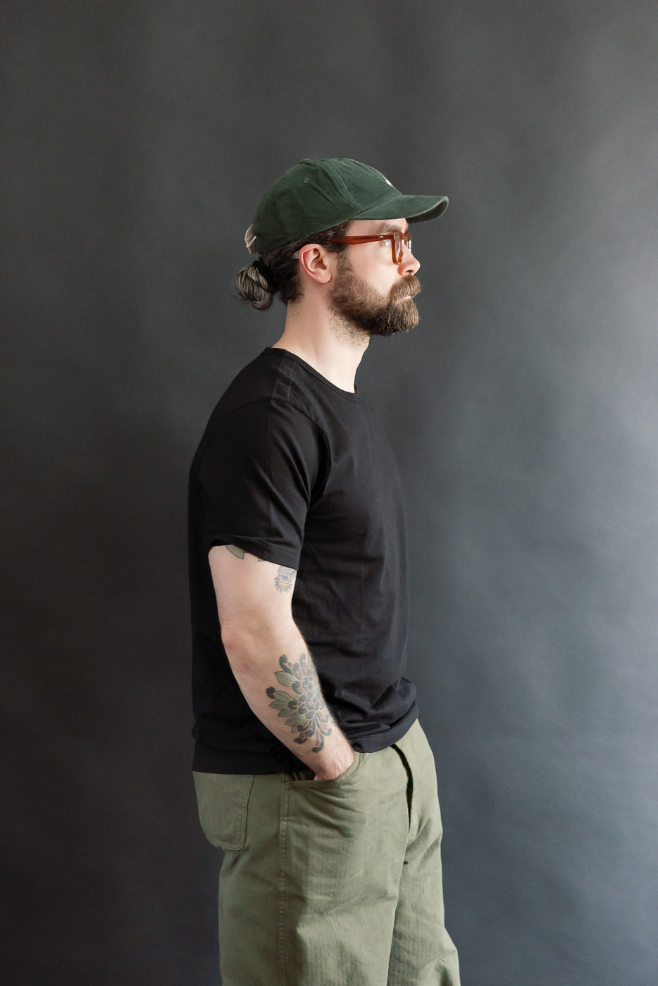 Male model 5'9 165lbs athletic build in classic fit deep black loopwheeled t-shirt, left side view, casual apparel at Dant
