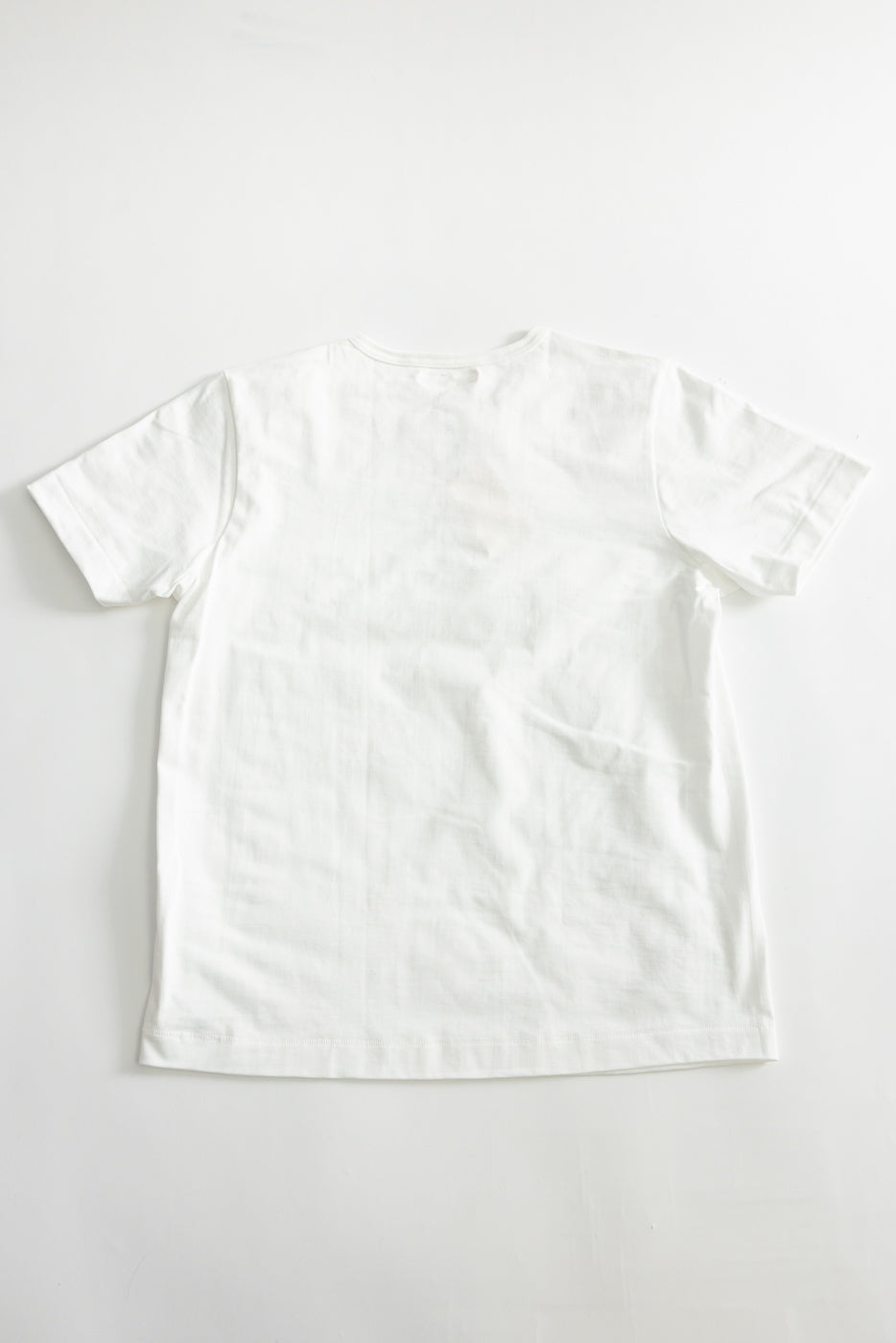 Flat lay of white loopwheeled t-shirt, back side, classic fit, short sleeve, no tags visible.