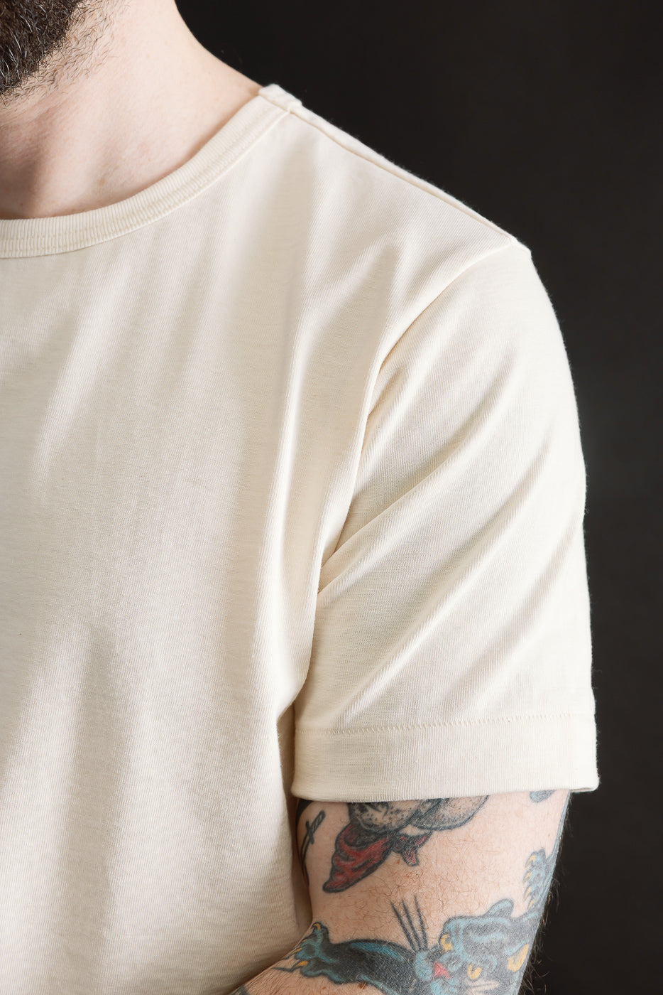 Close-up of right side, front shoulder and sleeve of loopwheeled cream t-shirt on male model, 5'9