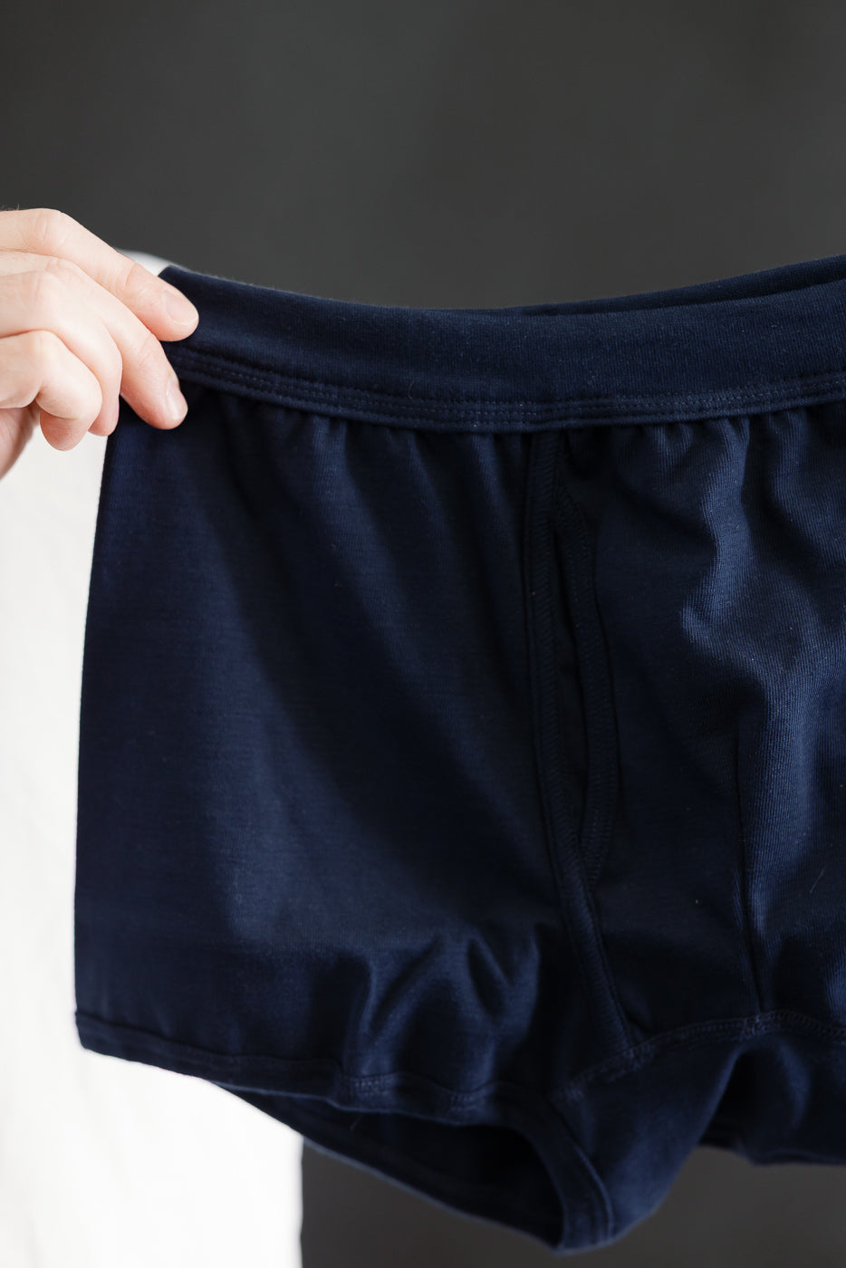 Hand holding 254.66 - Loopwheeled Boxer Brief - Ink Blue, showcasing the elastic waistband and smooth, stretchy fabric crafted from lightweight, loopwheeled cotton. Designed for comfort and fit, reflecting Dant's premium menswear ethos.