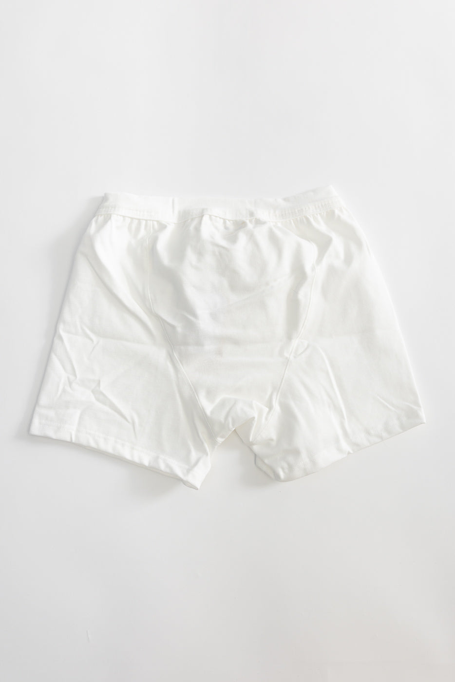 Flat lay of white loopwheeled boxer shorts, back view, showing waistband and full rear coverage.