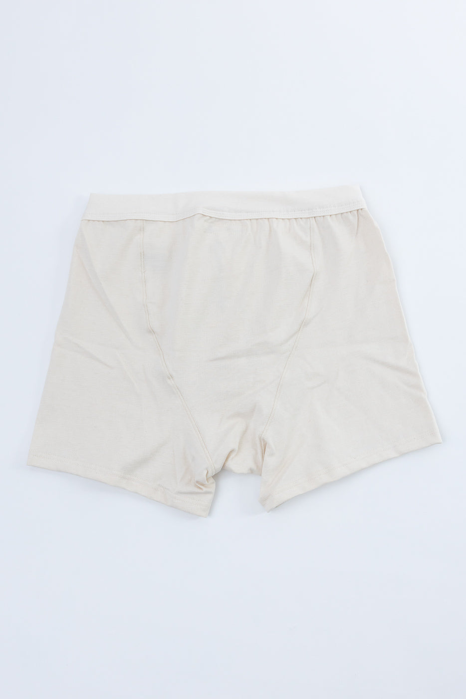 Flat lay of men's boxer shorts, back side, in natural off-white, loopwheeled cotton fabric