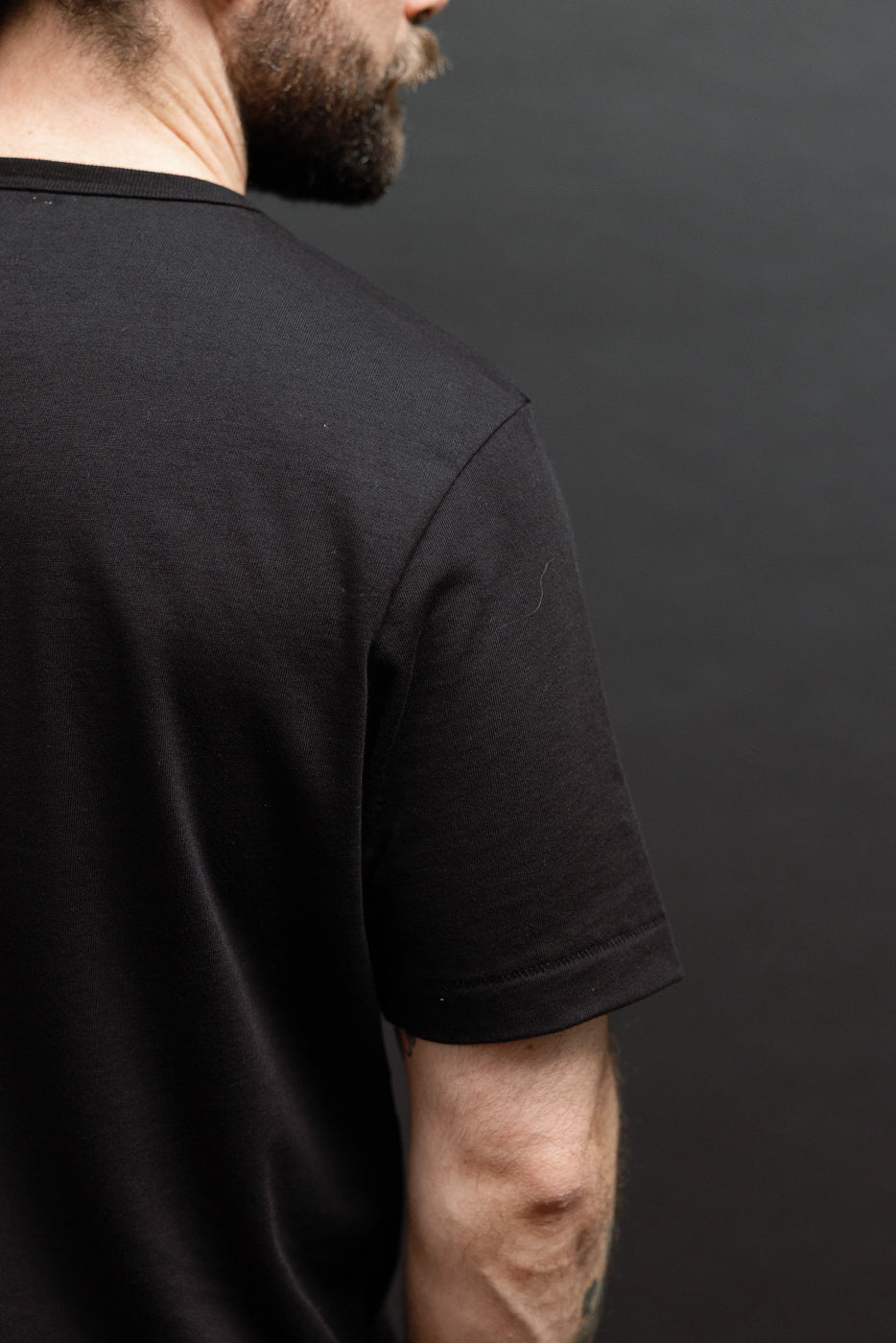 Side view close-up of a black cotton t-shirt on a 5'9