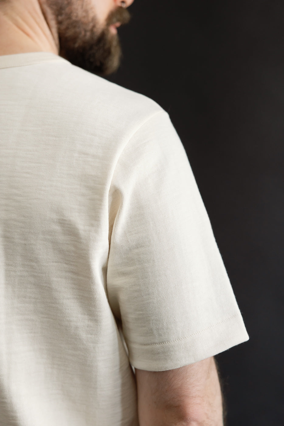 Close-up of the 2S14.02 - 10.7oz Loopwheeled Heavy T-Shirt Relaxed Fit - Nature, showcasing its textured neckline and slub fabric on the shoulder and upper back, worn casually by the model.