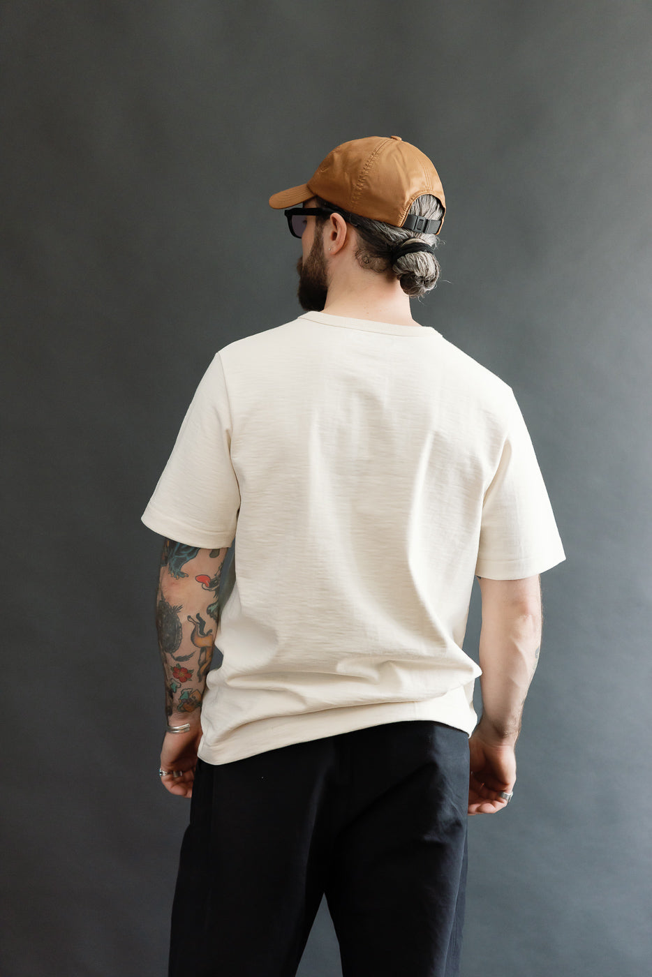 The image showcases a man wearing the 2S14.02 - 10.7oz Loopwheeled Heavy T-Shirt Relaxed Fit - Nature, highlighting its relaxed fit and unique slub texture, perfectly embodying Dant's premium menswear aesthetic.