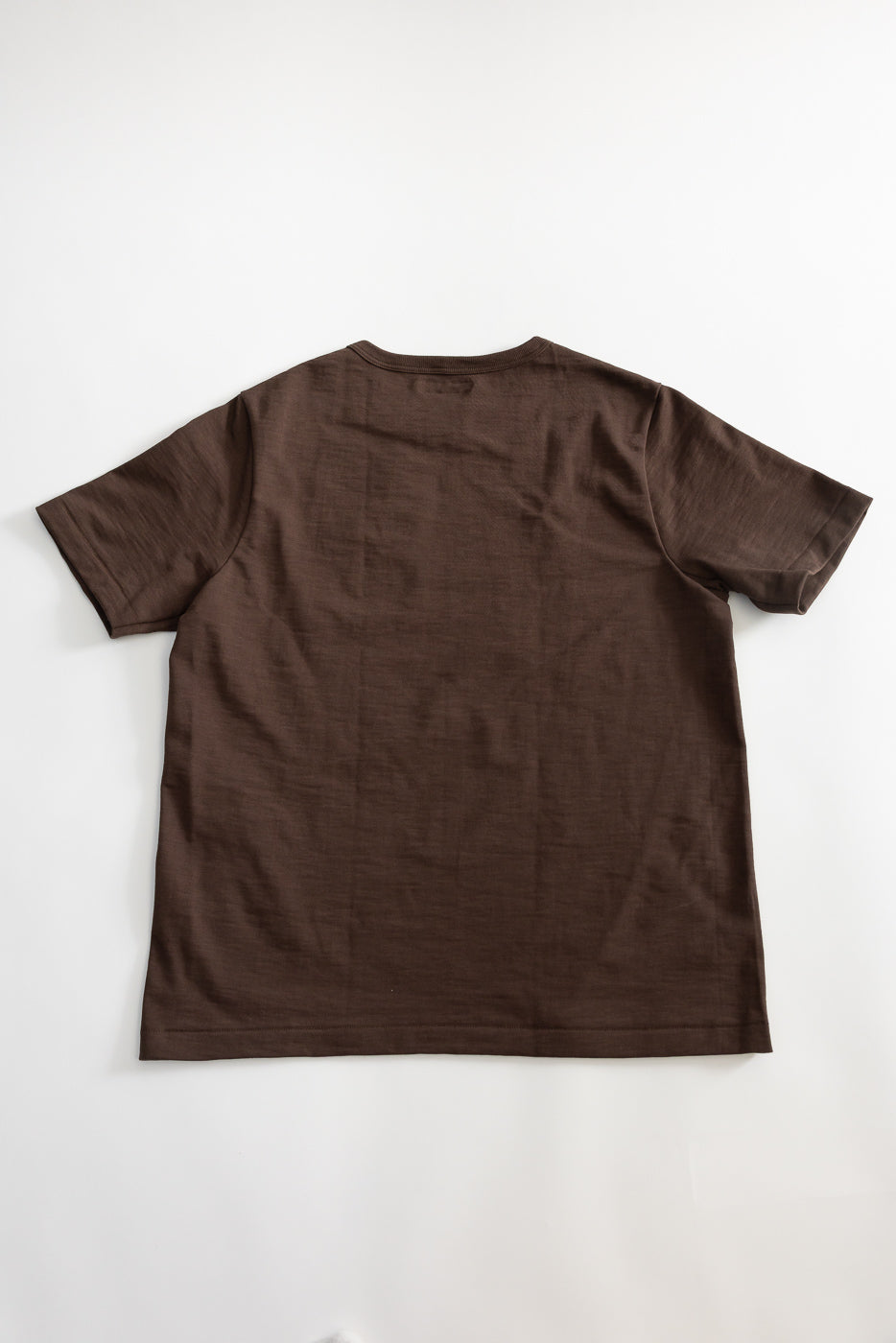 Flat lay of chocolate brown short sleeve t-shirt, back side, showing relaxed fit and hem.