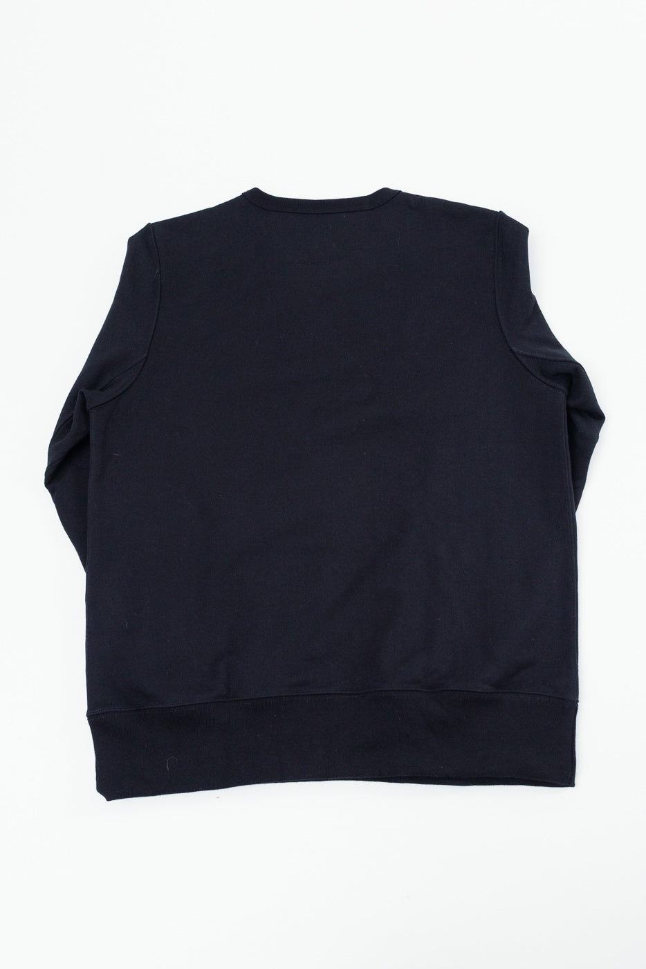 Back view flat lay of a black long-sleeve sweatshirt showing the rear panel and ribbed hem.