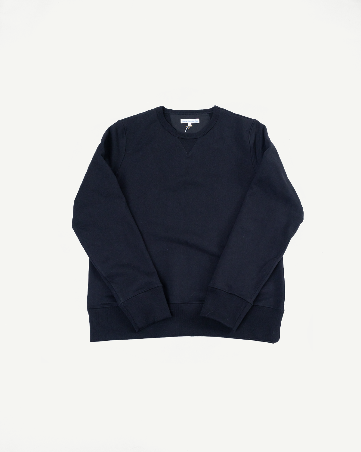Front view flat lay of a navy blue crewneck sweatshirt with ribbed cuffs and hem.
