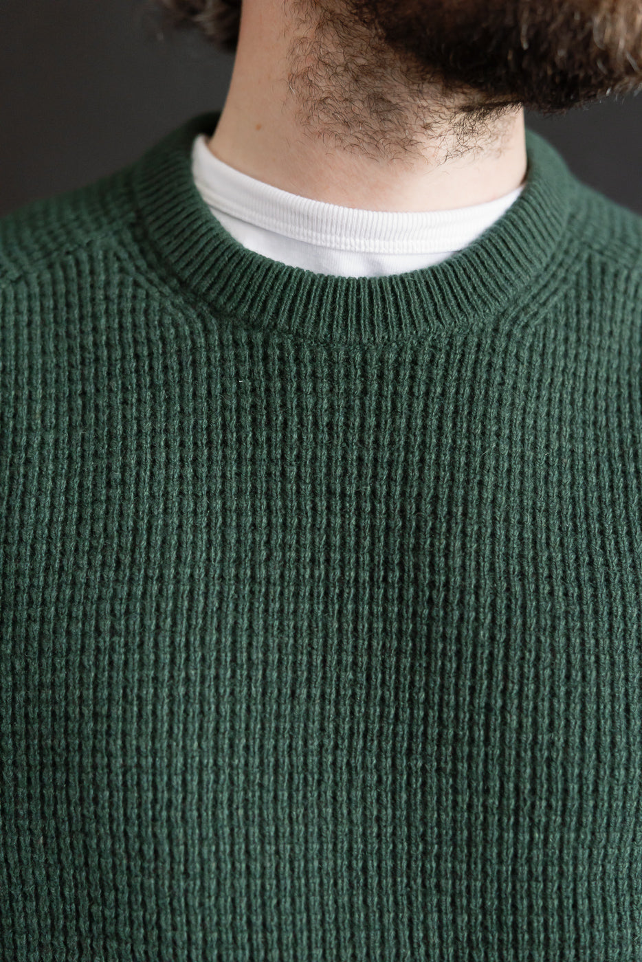 Close-up front of men's bottle green merino wool cashmere waffle pullover, ribbed collar detail.
