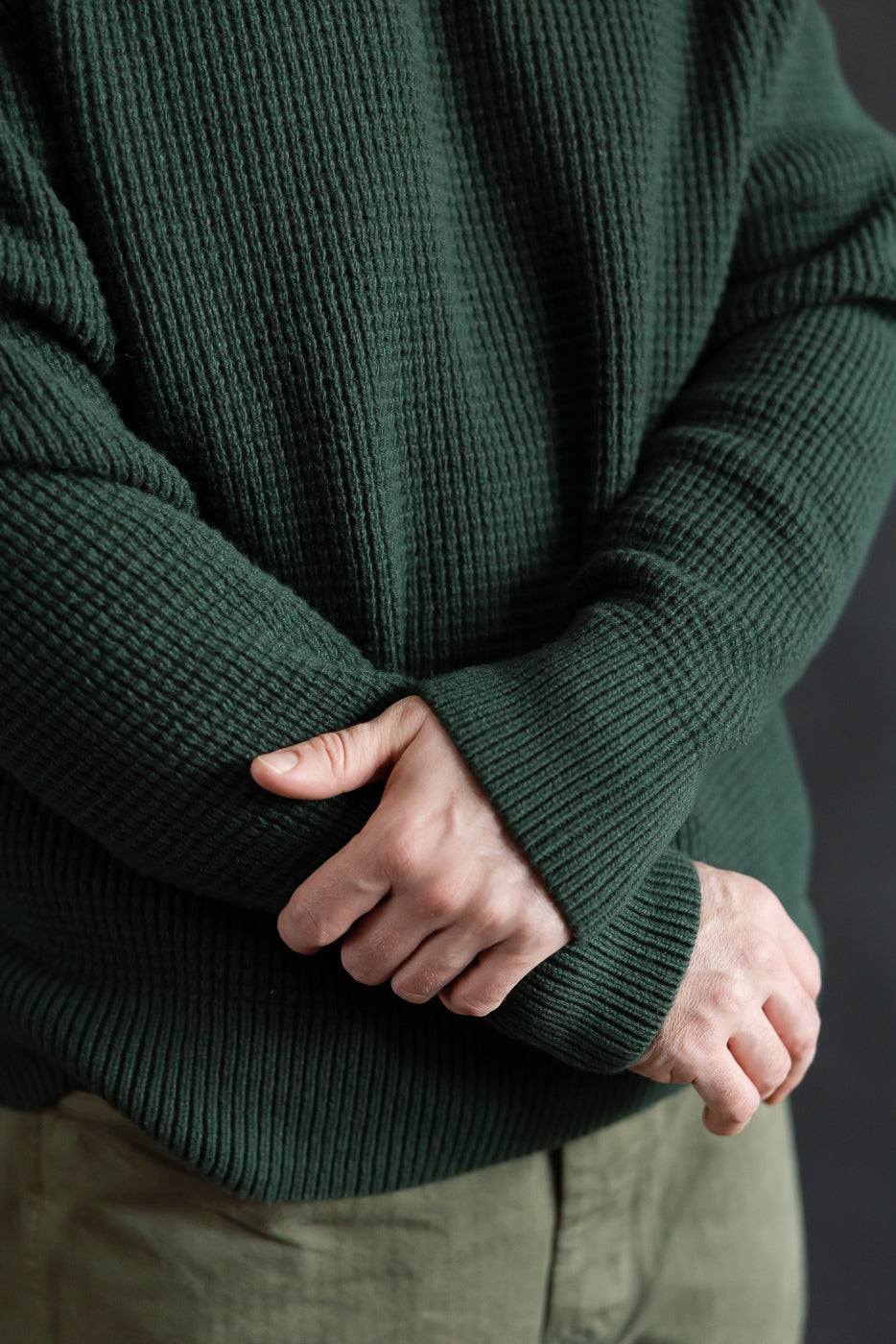 Close-up front of bottle green waffle knit Merz b. Schwanen pullover on male model, 5'9