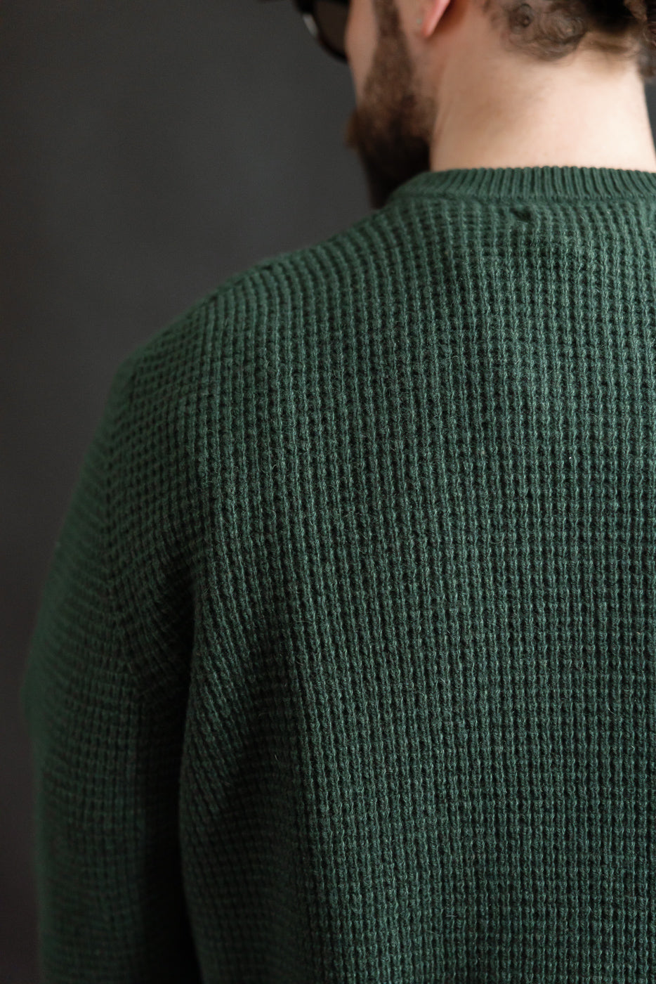 Close-up of back shoulder on men's bottle green waffle pullover, merino wool-cashmere blend, relaxed fit, athletic male model 5'9