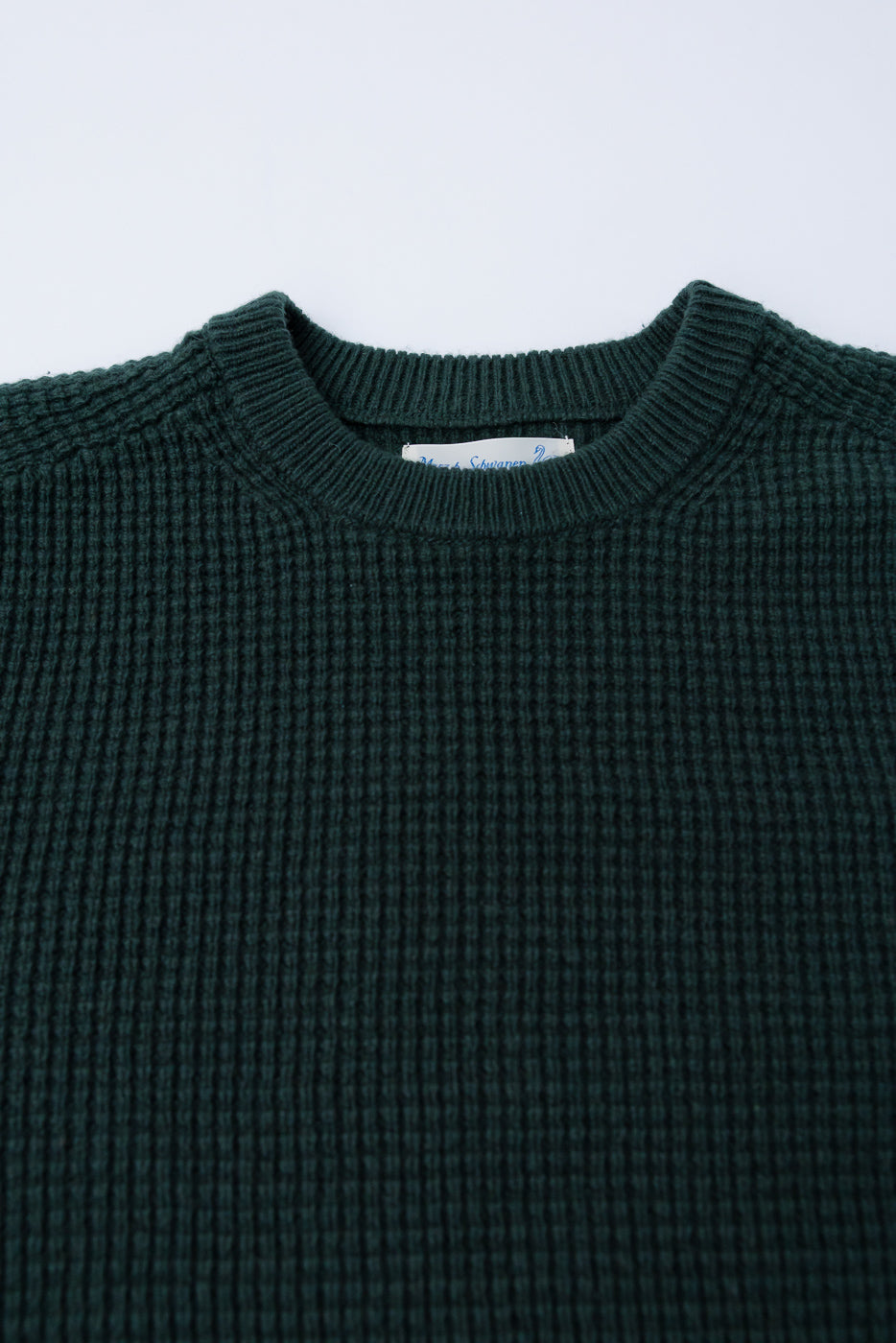Close-up front of Merz b. Schwanen bottle green waffle knit pullover, ribbed crewneck, textured merino wool-cashmere blend.