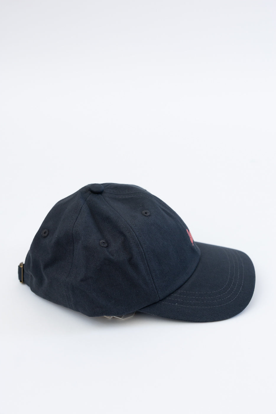 Side view flat lay of charcoal cotton twill cap with curved brim and metal buckle strap
