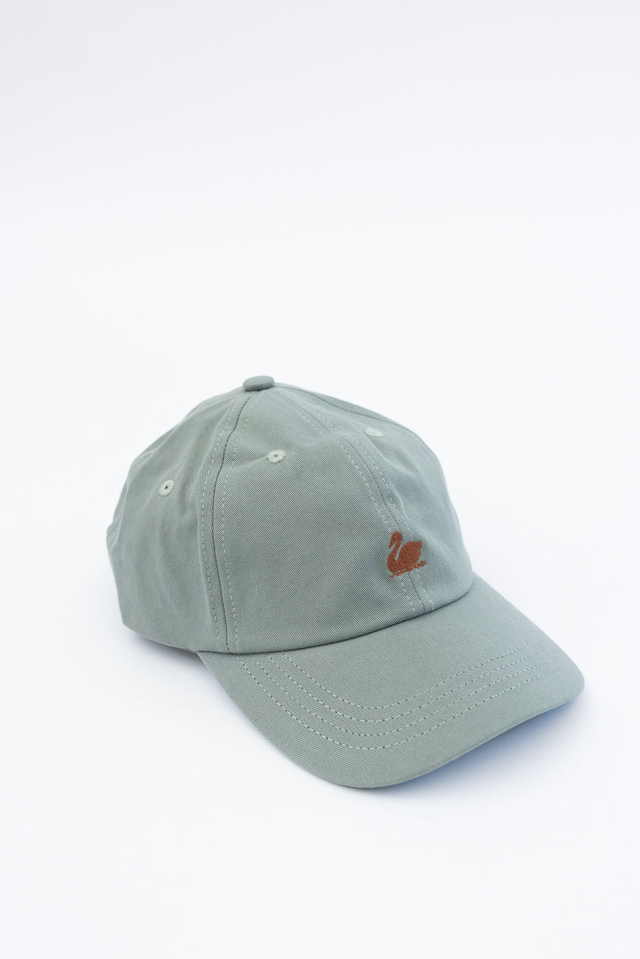 Close-up front view of light army green cotton twill cap with small embroidered swan logo.