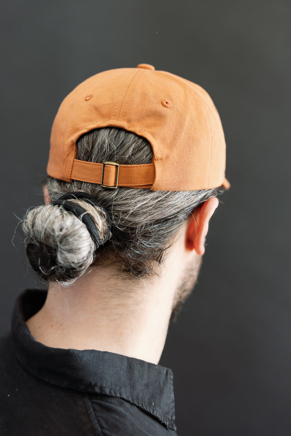 Back close-up of pumpkin orange cotton twill cap on male model 5'9
